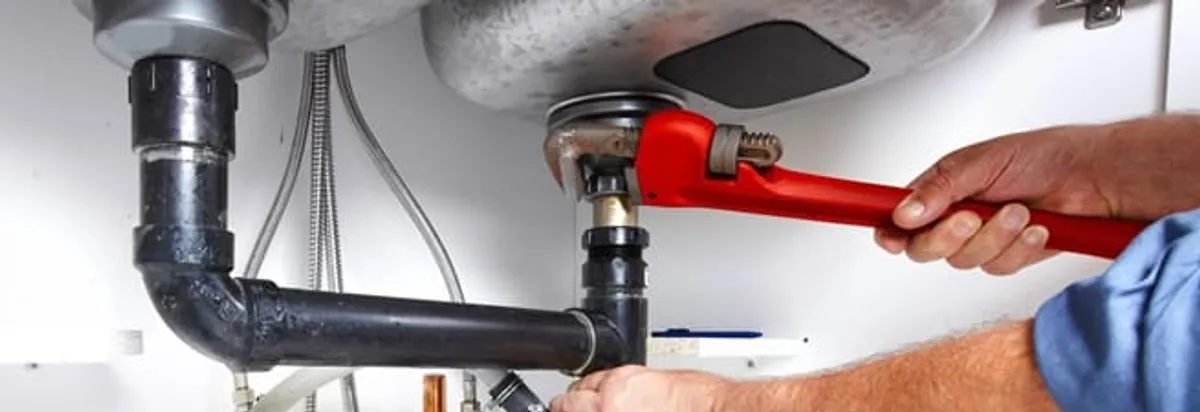 Garbage disposal repair technician tightening the sink drain and disposal connection in Springfield, MO