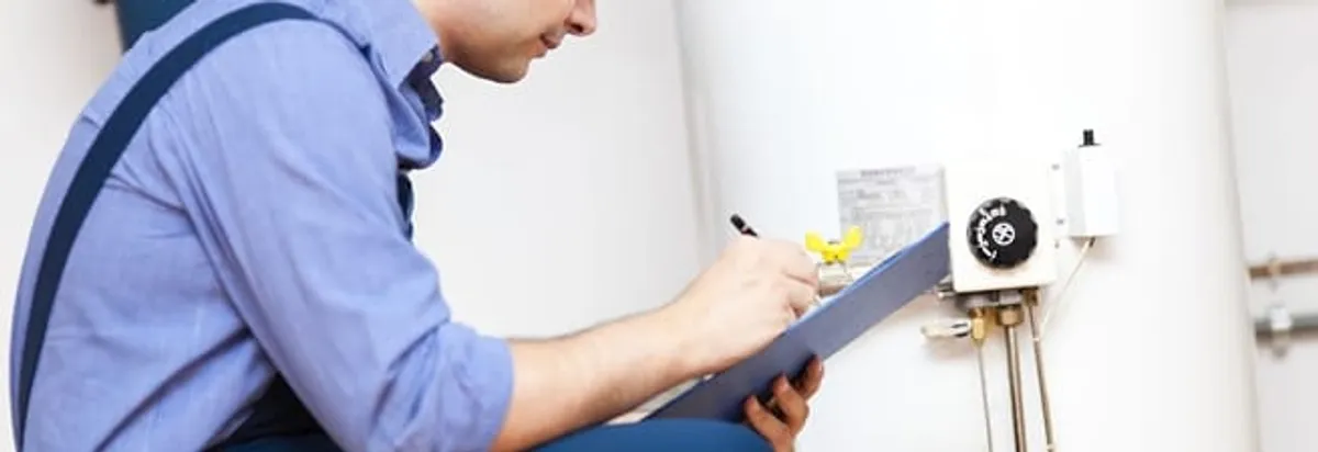 Water heater repair technician inspecting the unit and recording service notes in Springfield, MO